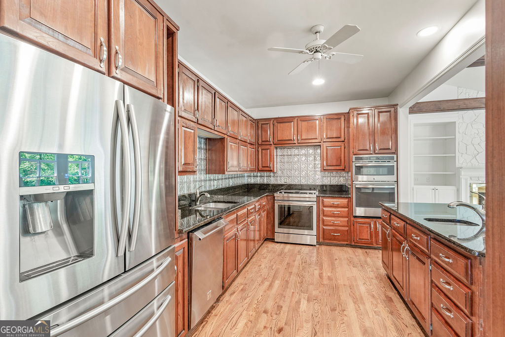 230 Haynes Road Moreland, GA 30259 - Photo 7 of 38 a kitchen with stainless steel appliances granite countertop a refrigerator a sink dishwasher a stove and white countertops with wooden floor