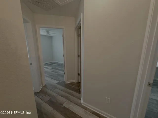 a view of empty room with wooden floor and fireplace