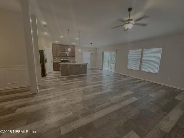 a view of a kitchen with kitchen island white cabinets and stainless steel appliances