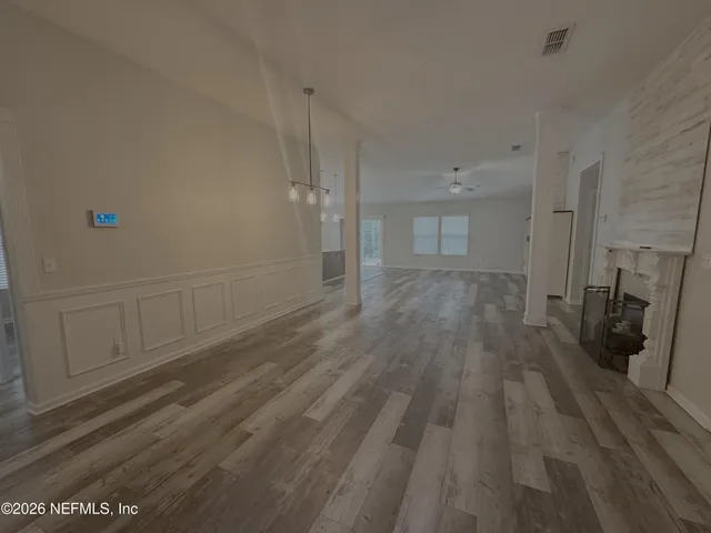 a view of a hallway with wooden floor and closet