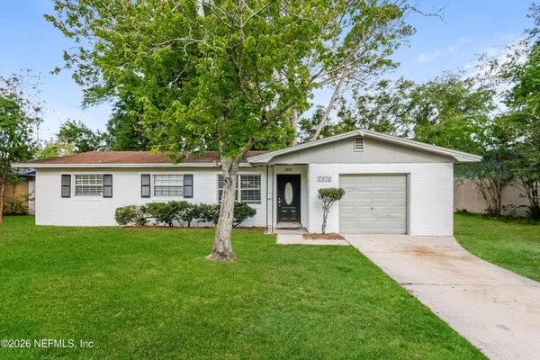 a front view of a house with a garden and yard