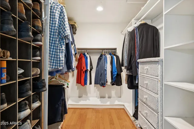 a view of walk in closet with clothes and shoes