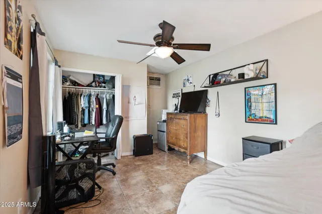 a bedroom with furniture a flat screen tv and a window