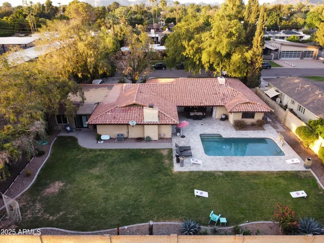 an aerial view of a house with swimming pool garden and patio