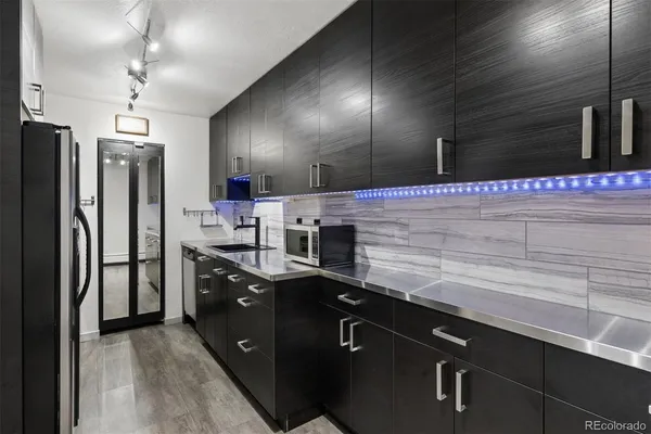 a kitchen with stainless steel appliances granite countertop a sink a stove and a refrigerator