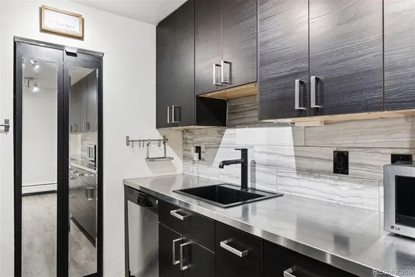 a kitchen with stainless steel appliances a sink and a refrigerator
