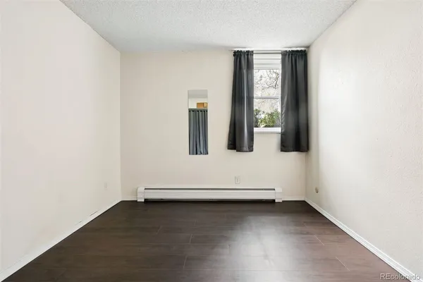 an empty room with wooden floor and window