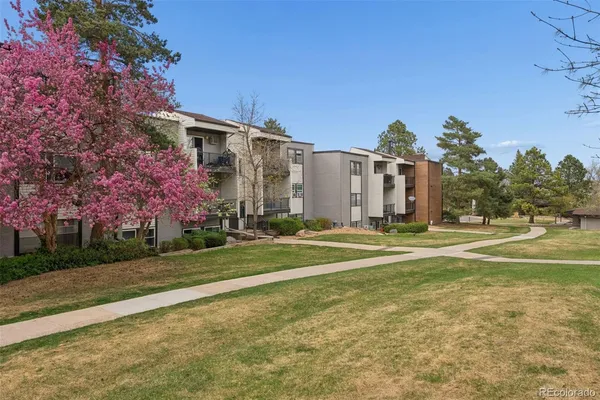 a view of a house with a big yard and large trees