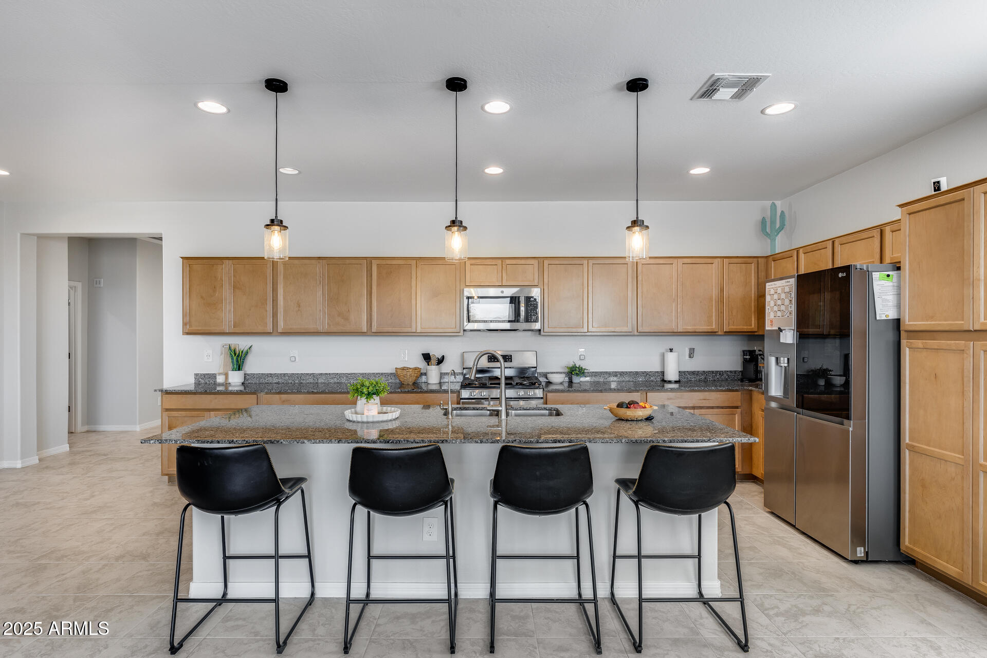 14866 West Sand Hills Road Surprise, AZ 85387 - Photo 20 of 54 a kitchen with stainless steel appliances granite countertop a sink a stove a refrigerator and island with wooden floor