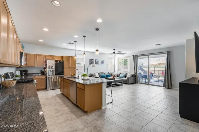 a large open kitchen with a large window and stainless steel appliances