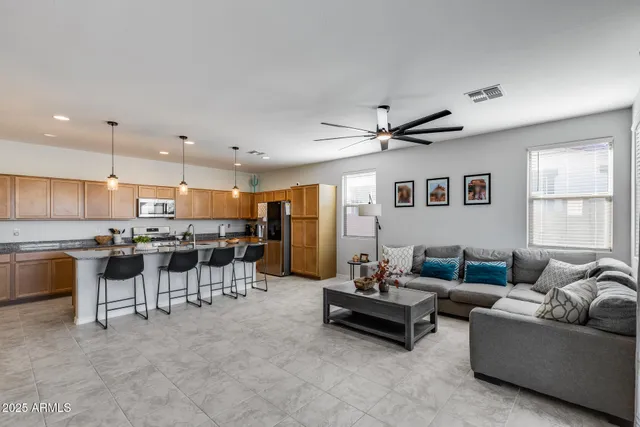 a living room with furniture kitchen view and a window