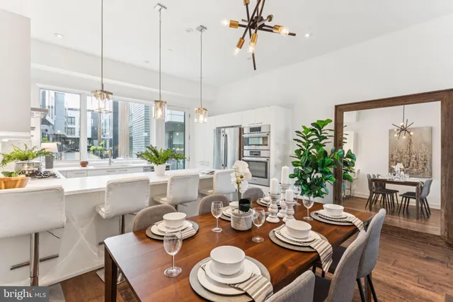 a dining room with furniture a large window and plants