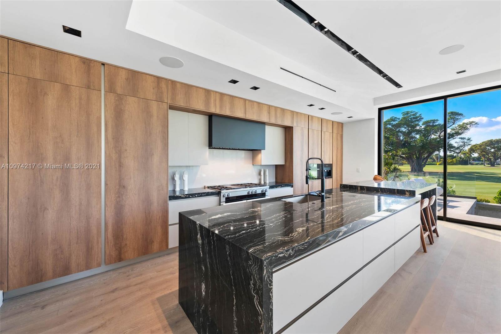 5470 La Gorce Drive Miami Beach, FL 33140 - Photo 16 of 71 a kitchen with stainless steel appliances granite countertop a sink a stove and a wooden floors