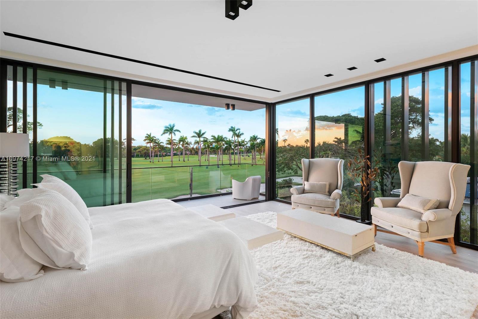 5470 La Gorce Drive Miami Beach, FL 33140 - Photo 27 of 71 a bed sitting in a bedroom next to a large window with balcony view