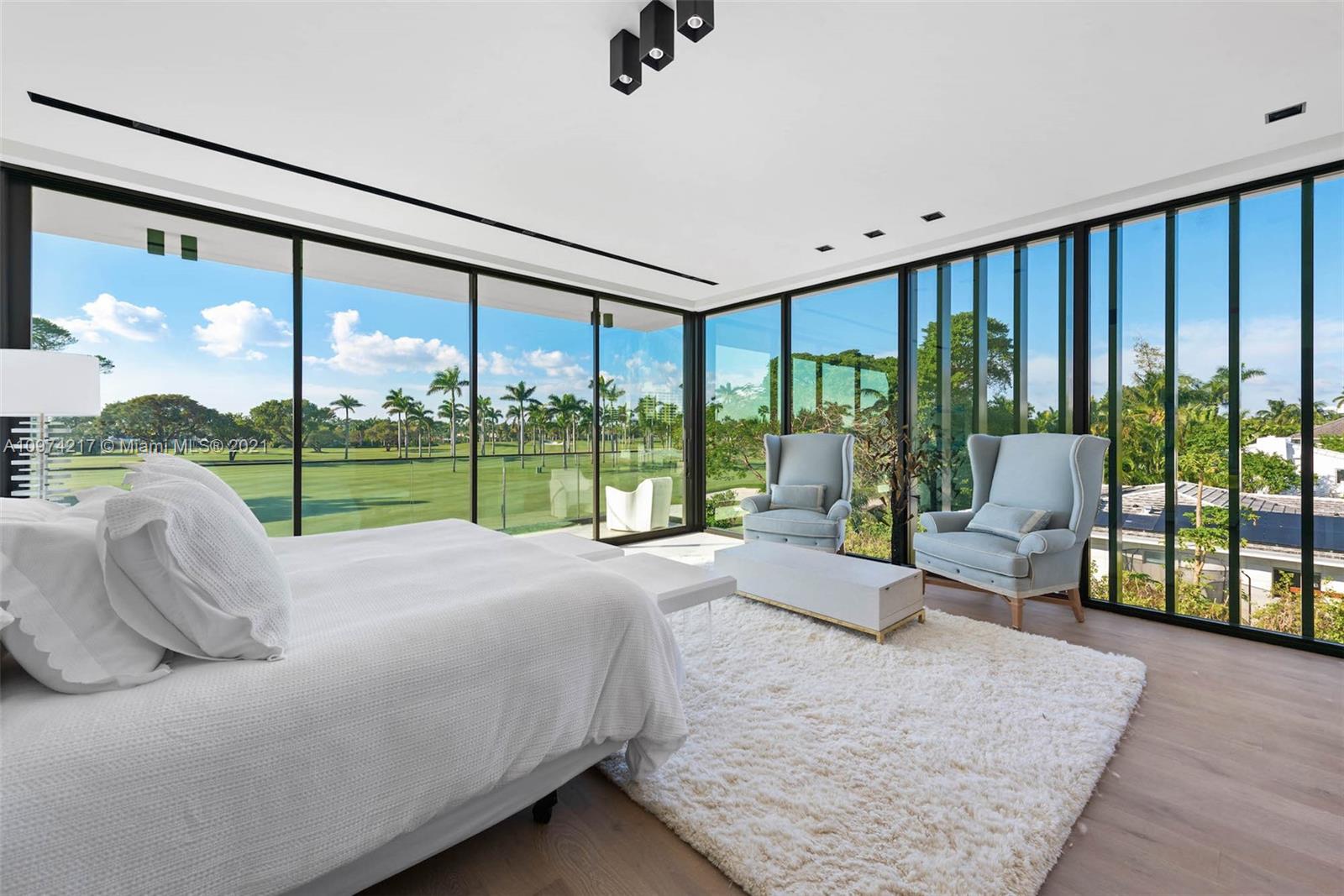 5470 La Gorce Drive Miami Beach, FL 33140 - Photo 32 of 71 a bed sitting in a bedroom next to a large window