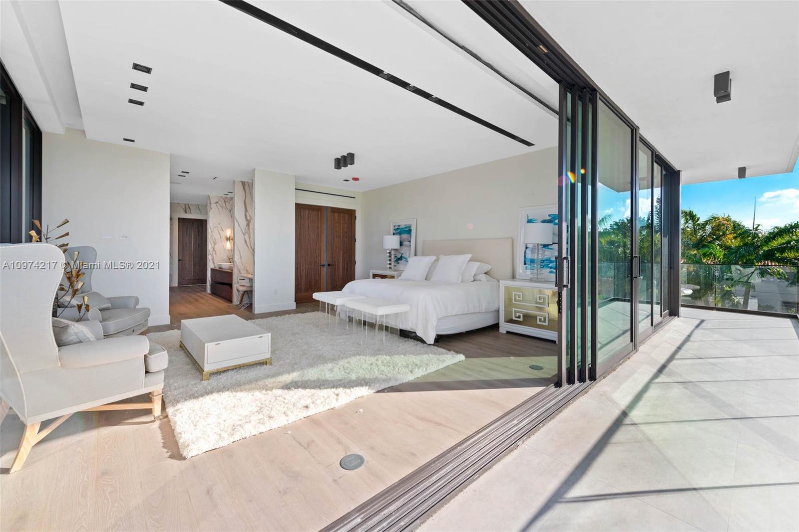 5470 La Gorce Drive Miami Beach, FL 33140 - Photo 37 of 71 a spacious bedroom with a bed and a large mirror