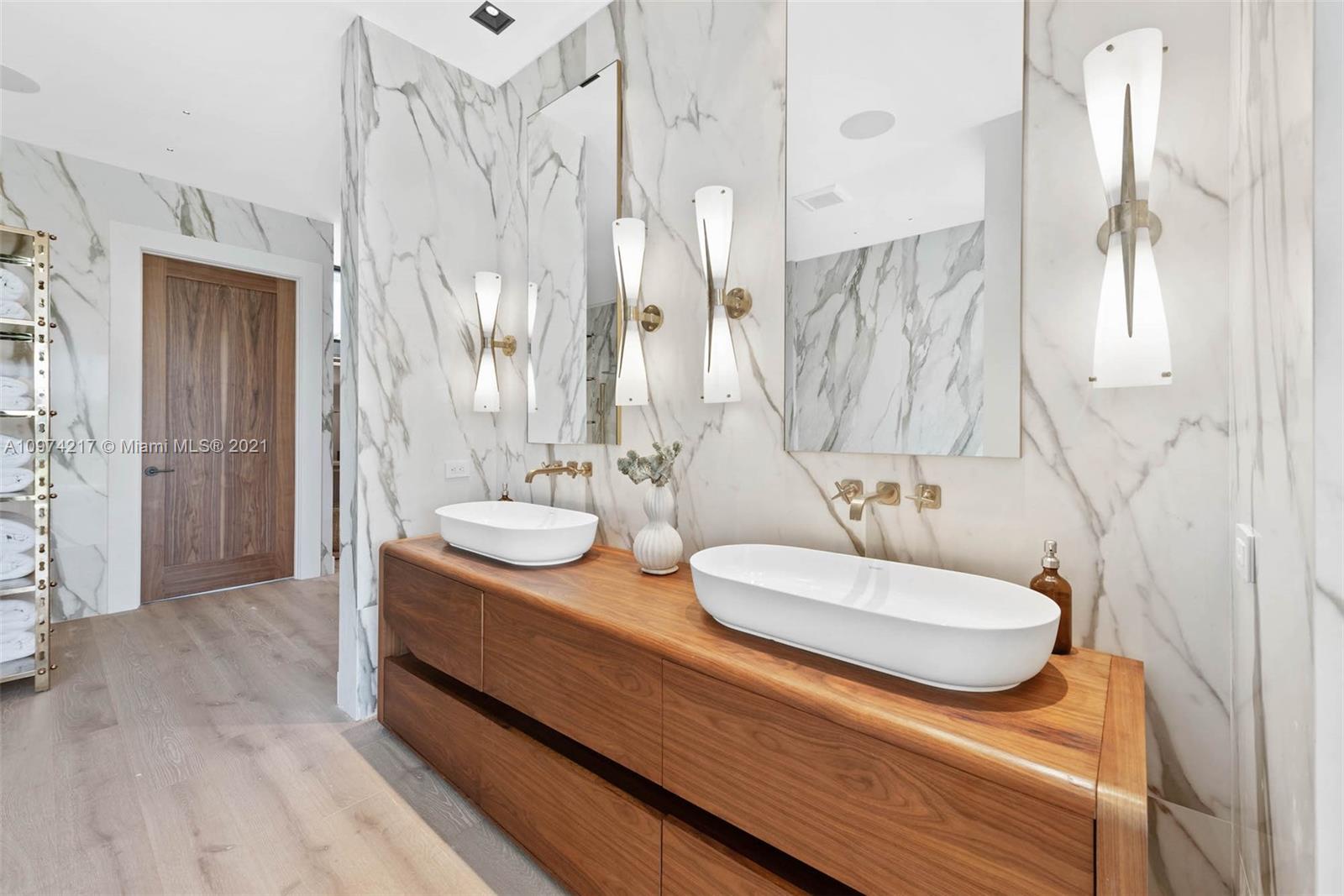 5470 La Gorce Drive Miami Beach, FL 33140 - Photo 43 of 71 a bathroom with double vanity sinks and a mirror