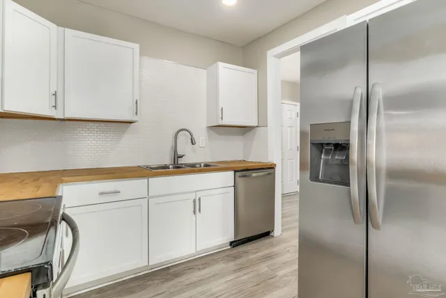a kitchen with granite countertop white cabinets and refrigerator