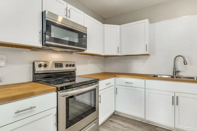 a kitchen with cabinets stainless steel appliances and a sink