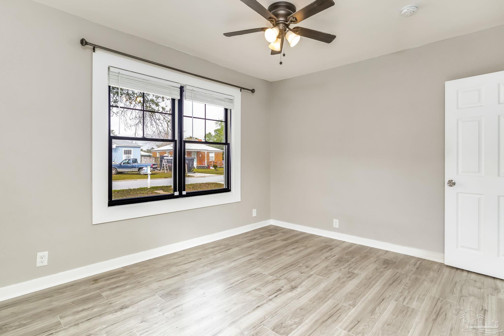 207 Bryant Road Pensacola, FL 32507 - Photo 13 of 23 a view of an empty room with wooden floor and a window