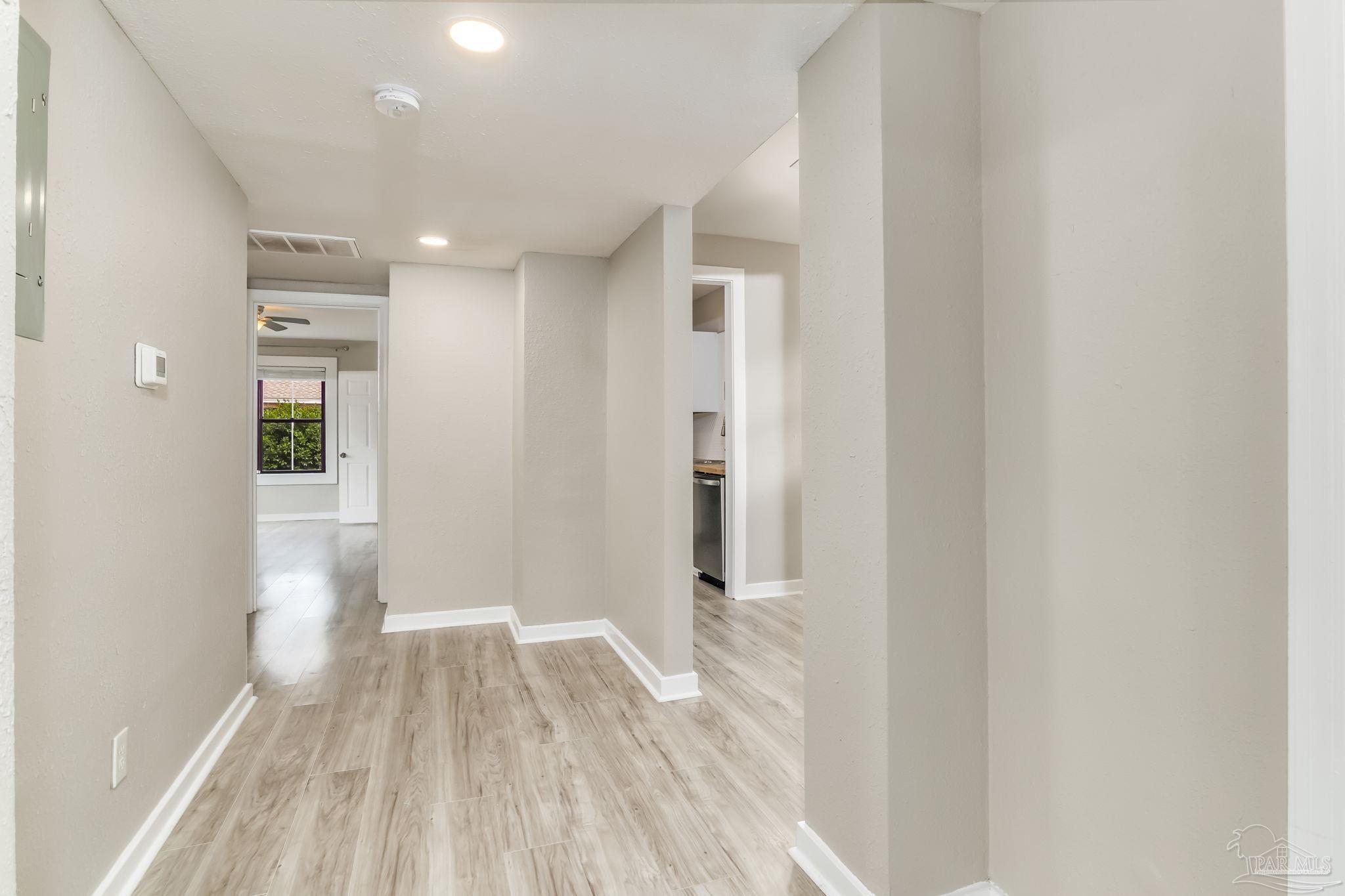 207 Bryant Road Pensacola, FL 32507 - Photo 16 of 23 a view of a hallway with wooden floor and a bathroom