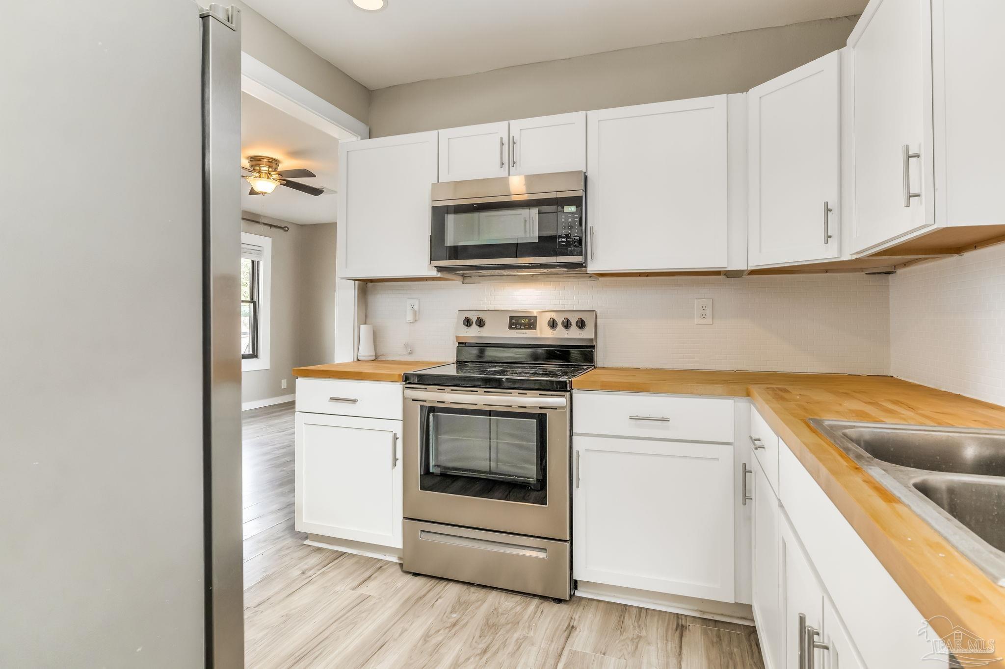 207 Bryant Road Pensacola, FL 32507 - Photo 10 of 23 a kitchen with stainless steel appliances granite countertop a sink a stove and microwave