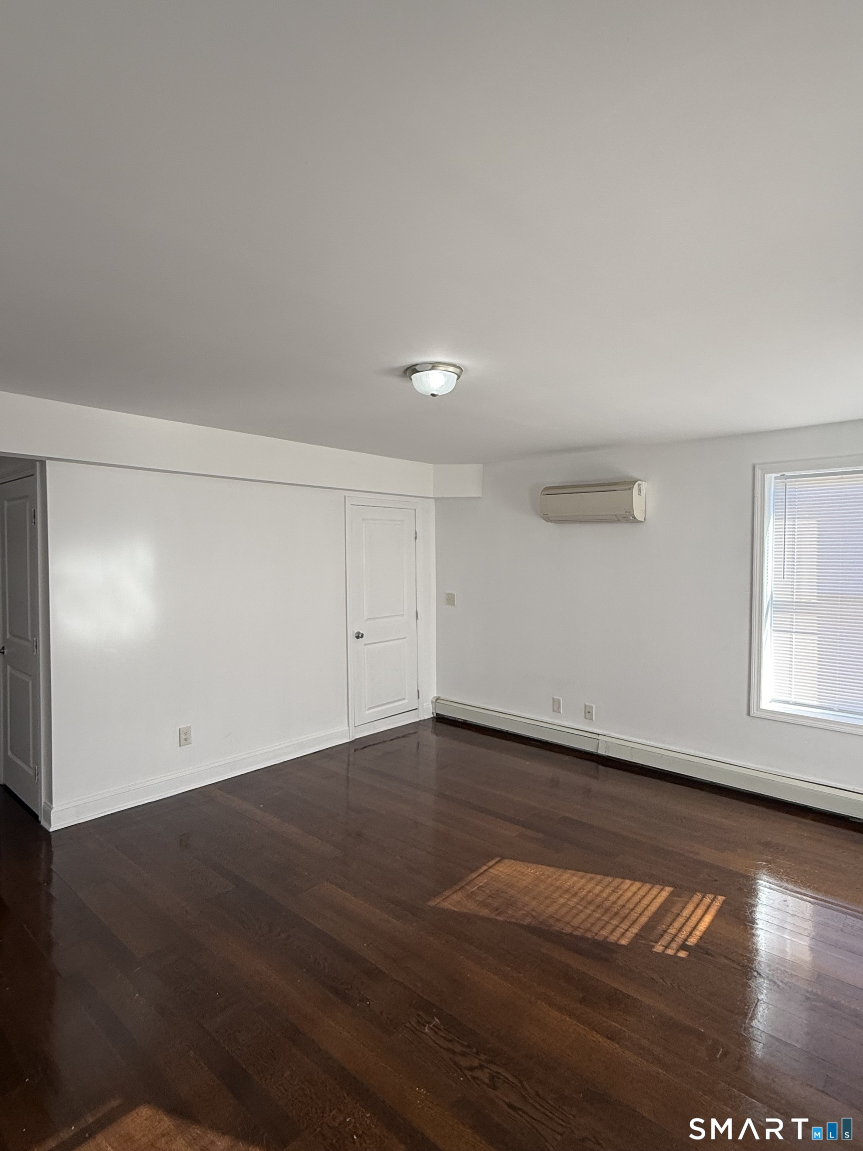 29 Moulthrop Street, Unit 1 Ansonia, CT 06401 - Photo 3 of 11 an empty room with wooden floor and windows