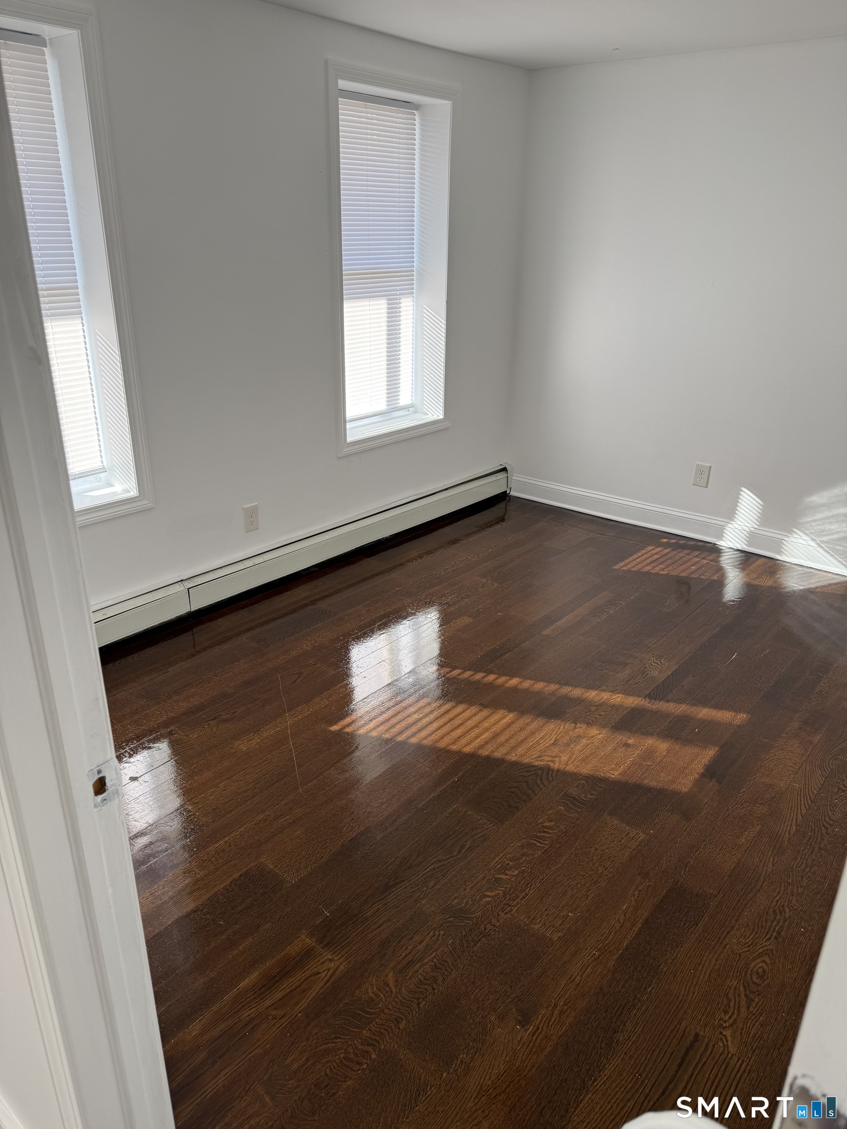 29 Moulthrop Street, Unit 1 Ansonia, CT 06401 - Photo 8 of 11 an empty room with wooden floor and windows