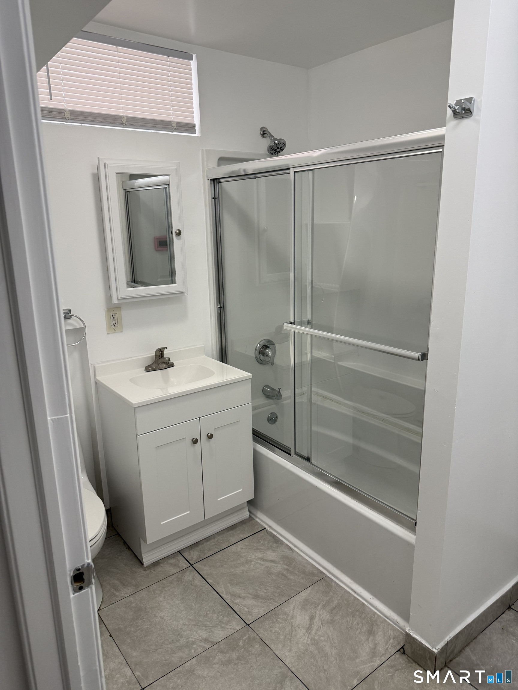 29 Moulthrop Street, Unit 1 Ansonia, CT 06401 - Photo 10 of 11 a bathroom with a shower sink and mirror