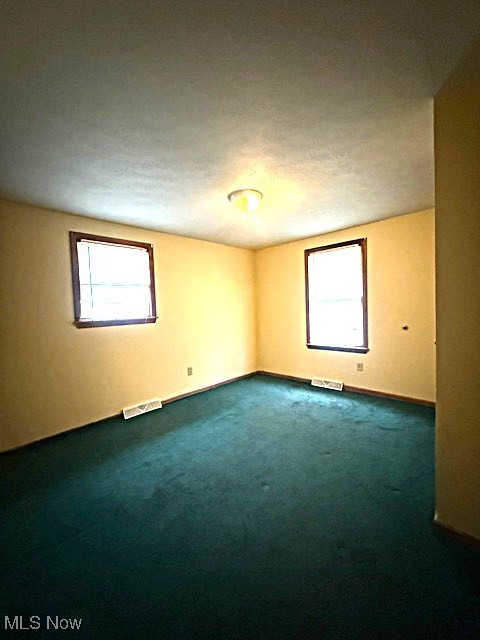 3804 Mahoning Road Northeast Canton, OH 44705 - Photo 10 of 22 Unfurnished room featuring baseboards, dark colored carpet, and visible vents