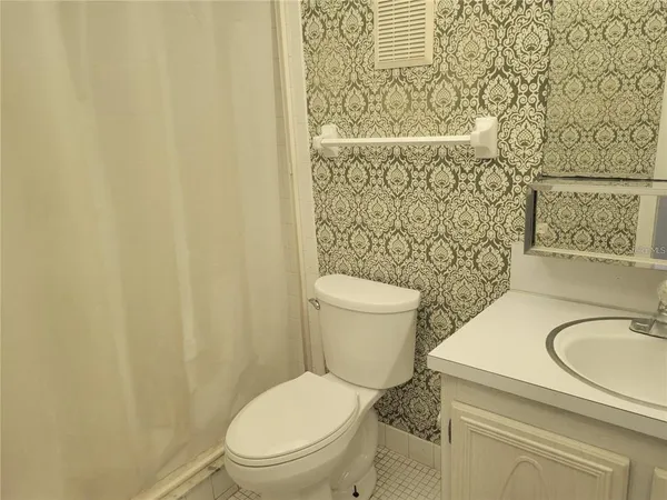 a white toilet sitting next to a shower curtain