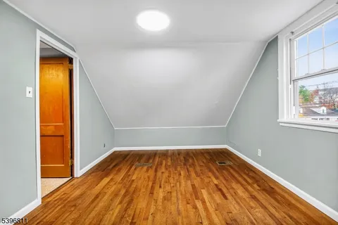 a view of a big room with wooden floor and windows