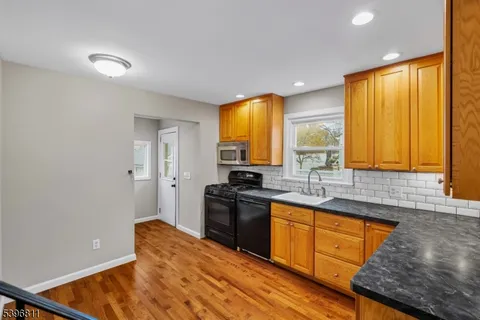 a kitchen with stainless steel appliances granite countertop a sink a stove and a refrigerator