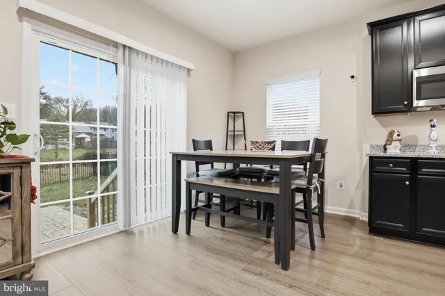 a kitchen with stainless steel appliances a table chairs refrigerator and cabinets