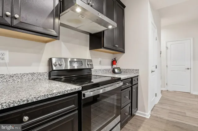 a kitchen with granite countertop a sink and a wooden floor