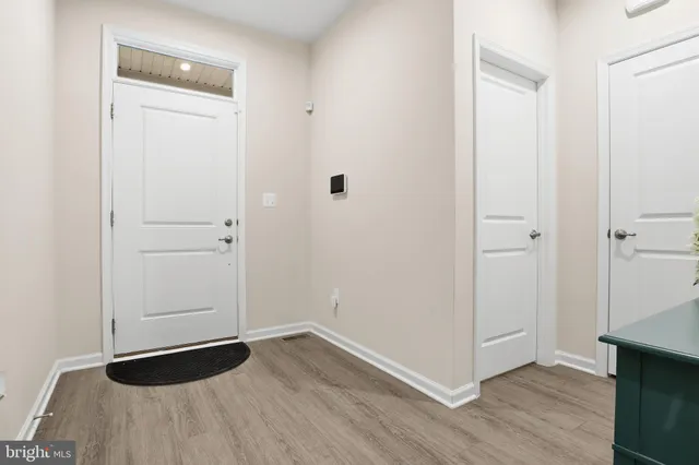 a kitchen with stainless steel appliances granite countertop a stove top oven a sink dishwasher and a refrigerator with wooden floor