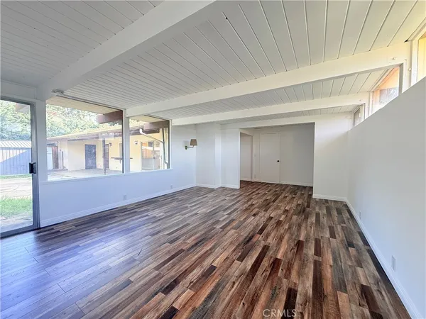 a view of a room with wooden floor and windows