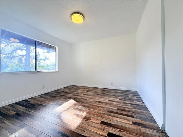 a view of a room with wooden floor and window