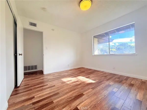 a view of empty room with wooden floor