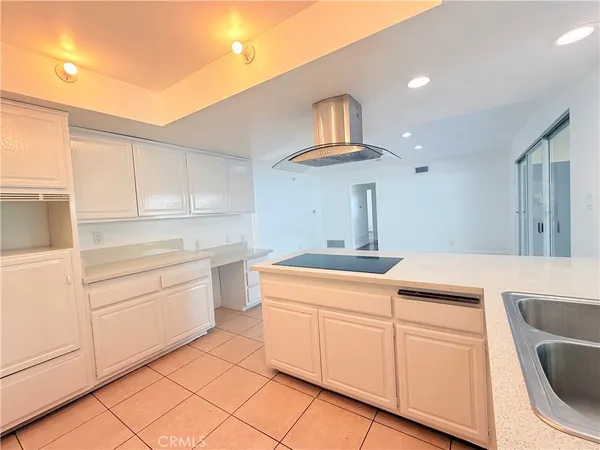 a kitchen with white cabinets and sink
