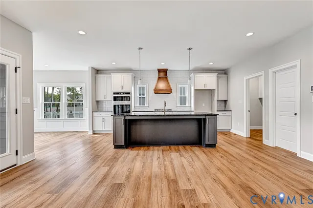 a large kitchen with stainless steel appliances granite countertop a large counter top a sink and a refrigerator