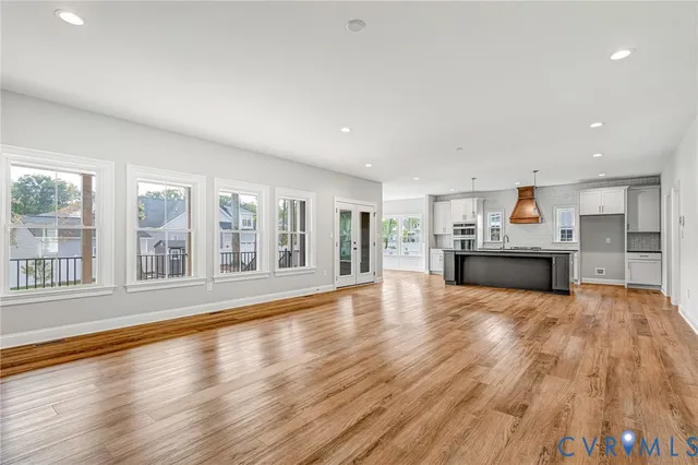 a view of empty room with wooden floor and windows