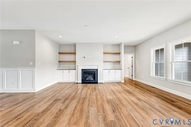 a view of empty room with a fireplace and wooden floor