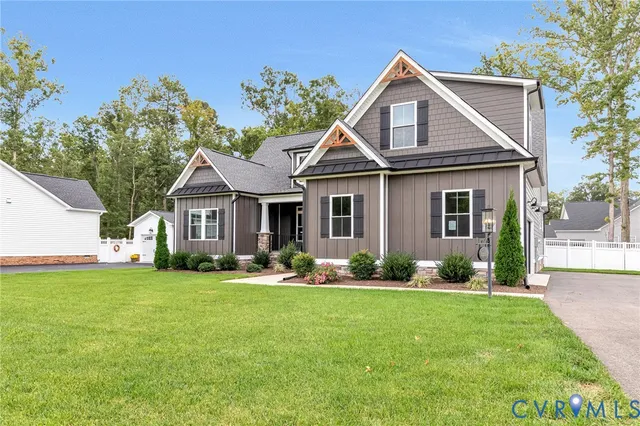 a front view of a house with a big yard and potted plants