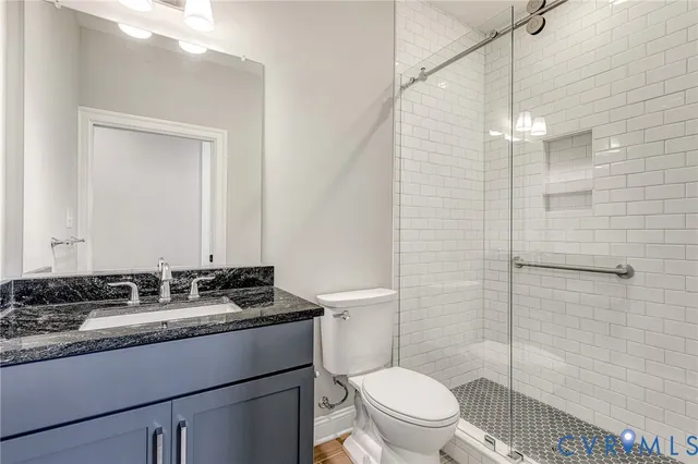 a bathroom with a granite countertop sink toilet and shower