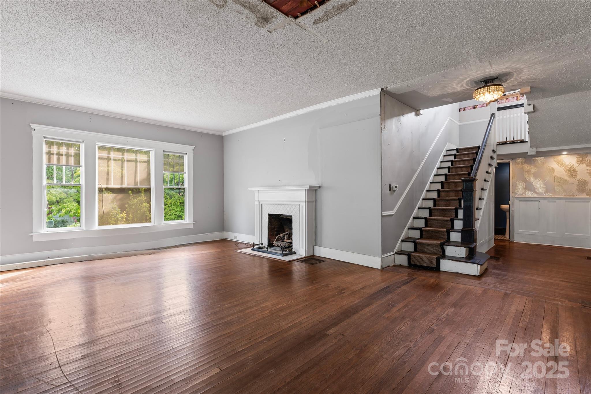 701 South Fulton Street Salisbury, NC 28144 - Photo 7 of 21 an empty room with wooden floor staircase and windows