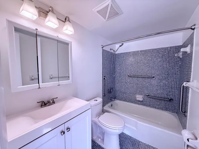 a bathroom with a sink a toilet a mirror and bathtub