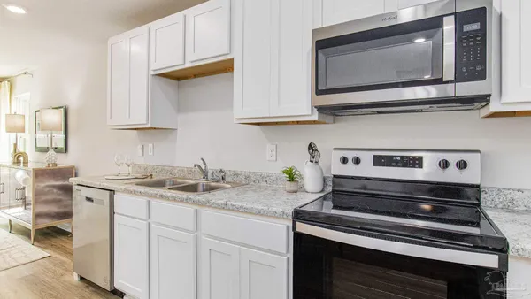 a kitchen with stainless steel appliances granite countertop a stove microwave and sink