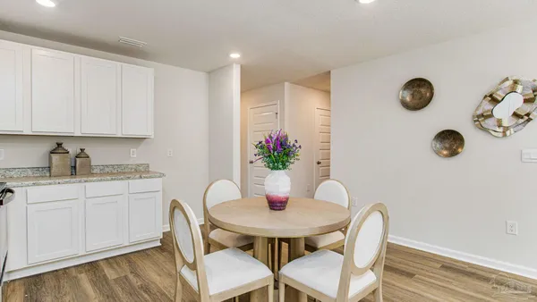 a dining room with furniture and wooden floor