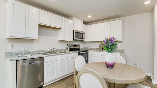 a kitchen with sink a microwave and cabinets